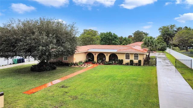 an aerial view of a house with a yard and lake view
