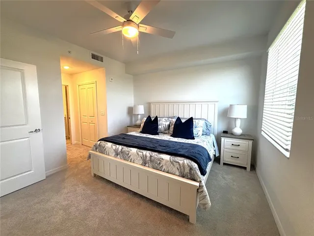 a spacious bedroom with a bed and a chandelier