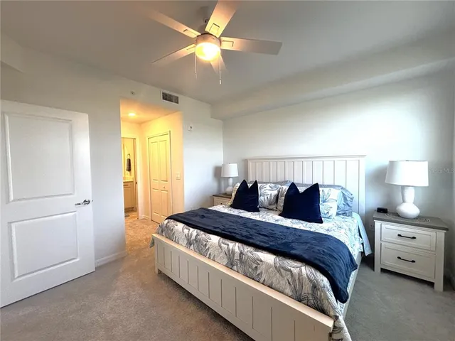 a bedroom with a large bed and a chandelier