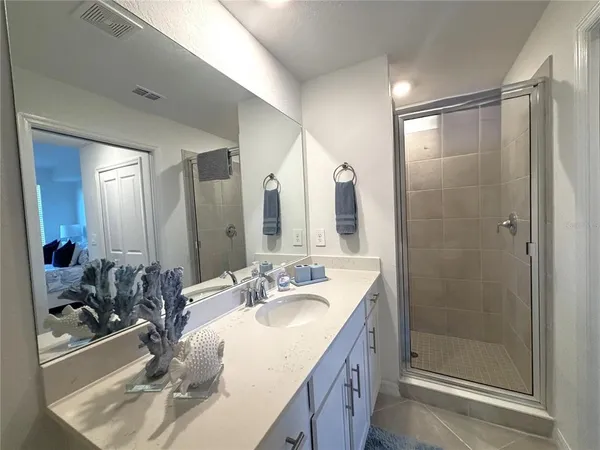a bathroom with 2 sink shower and a mirror