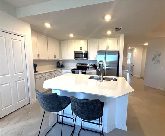 a large kitchen with kitchen island a sink table and chairs