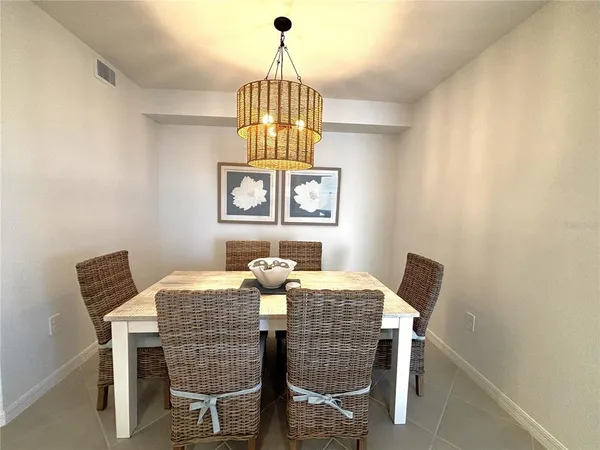 a dining room with furniture a chandelier and wooden floor