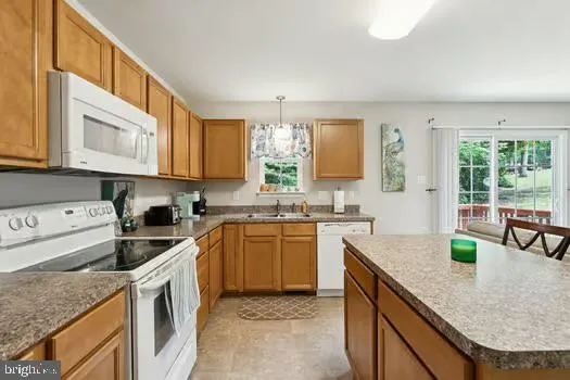 a kitchen with granite countertop a sink a stove and cabinets