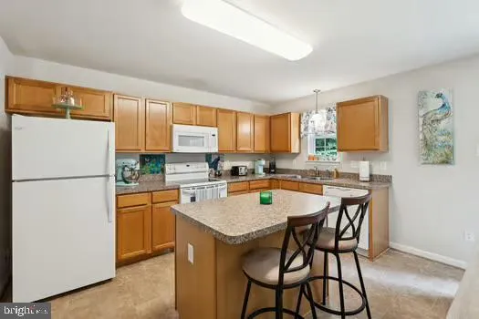 a kitchen with a refrigerator a stove a sink and white cabinets with wooden floor