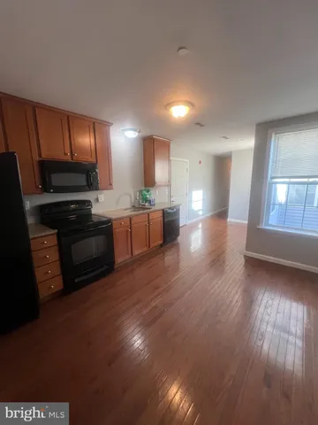 a view of kitchen with stove and refrigerator