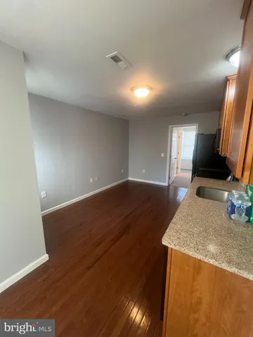 a view of a kitchen with kitchen island a sink wooden floor and a glass door
