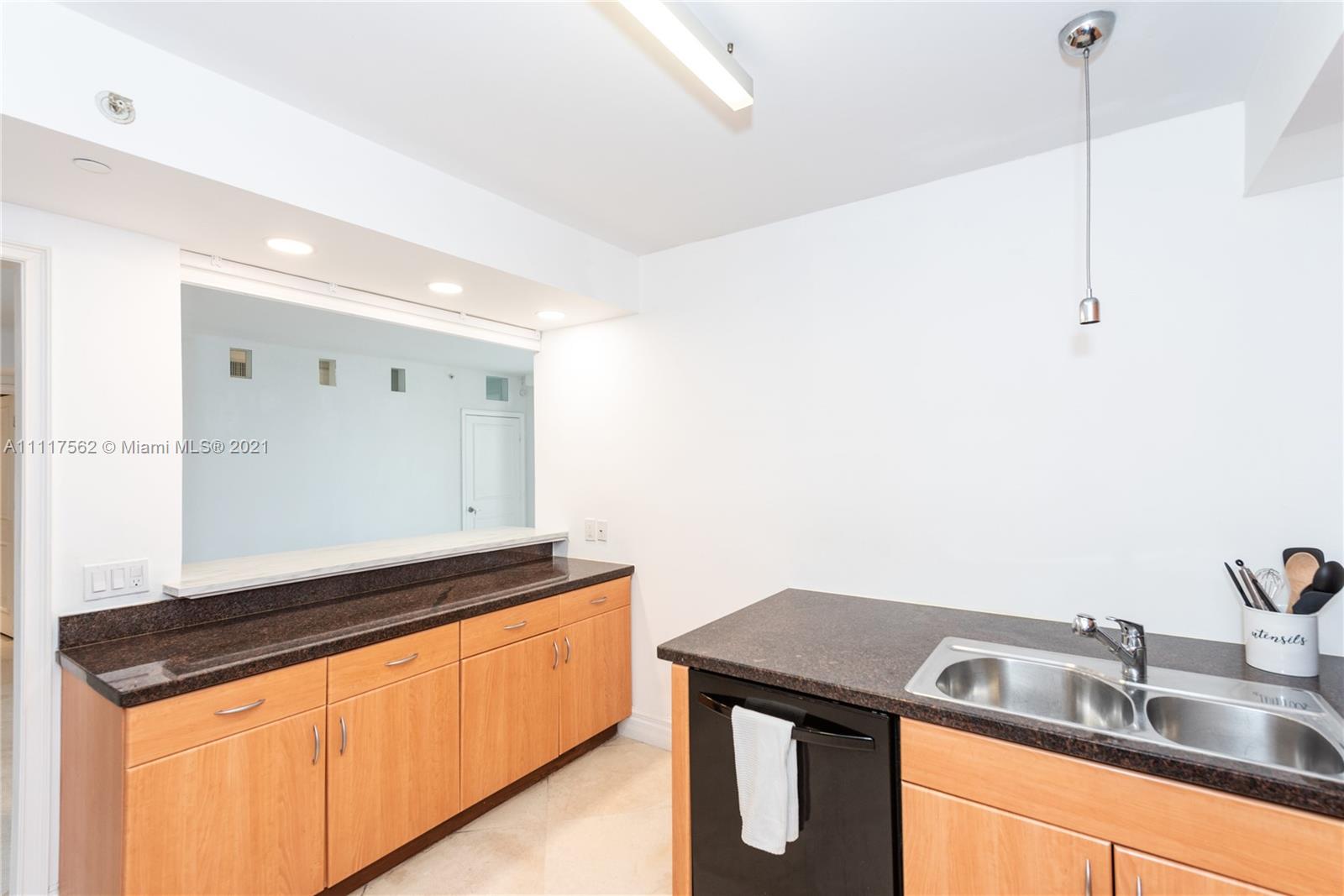 765 Crandon Boulevard, Unit 504 Key Biscayne, FL 33149 - Photo 11 of 46 a kitchen that has a sink a stove and a microwave oven