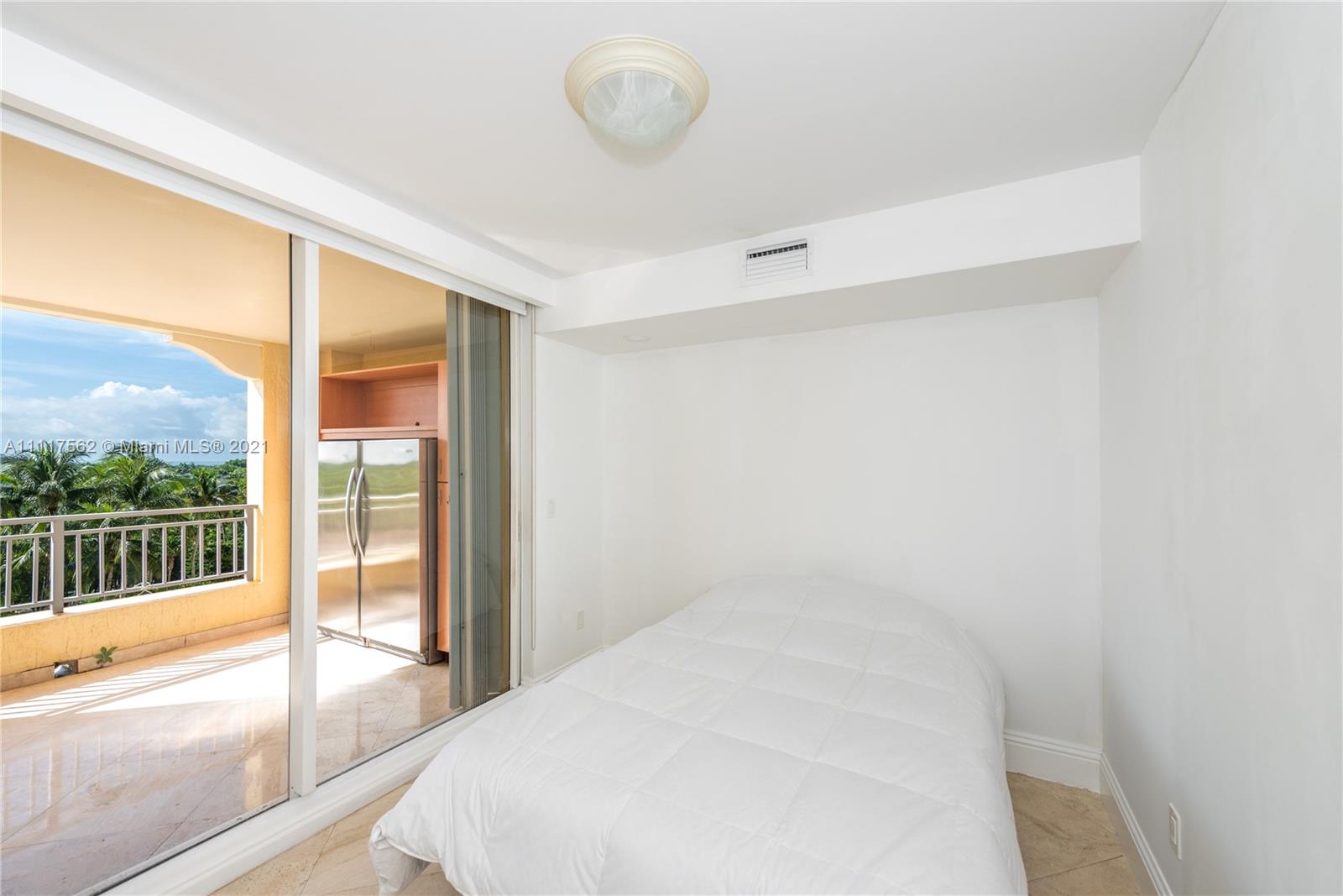 765 Crandon Boulevard, Unit 504 Key Biscayne, FL 33149 - Photo 18 of 46 a large white bed in a room next to a window