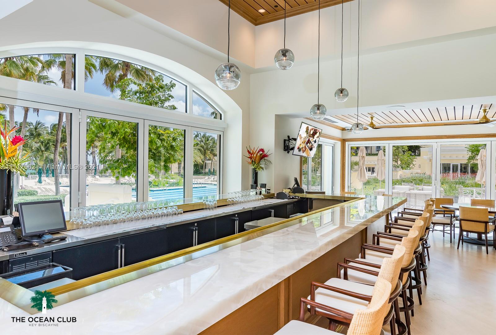 765 Crandon Boulevard, Unit 504 Key Biscayne, FL 33149 - Photo 32 of 46 a large swimming pool with lawn chairs