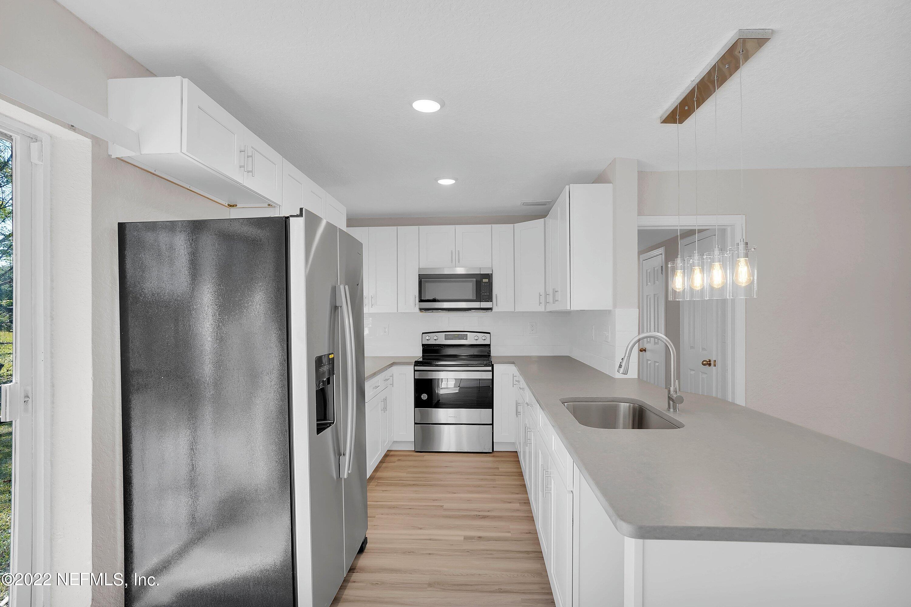 6631 Champlain Road Jacksonville, FL 32208 - Photo 12 of 25 a kitchen with stainless steel appliances granite countertop a refrigerator and a sink