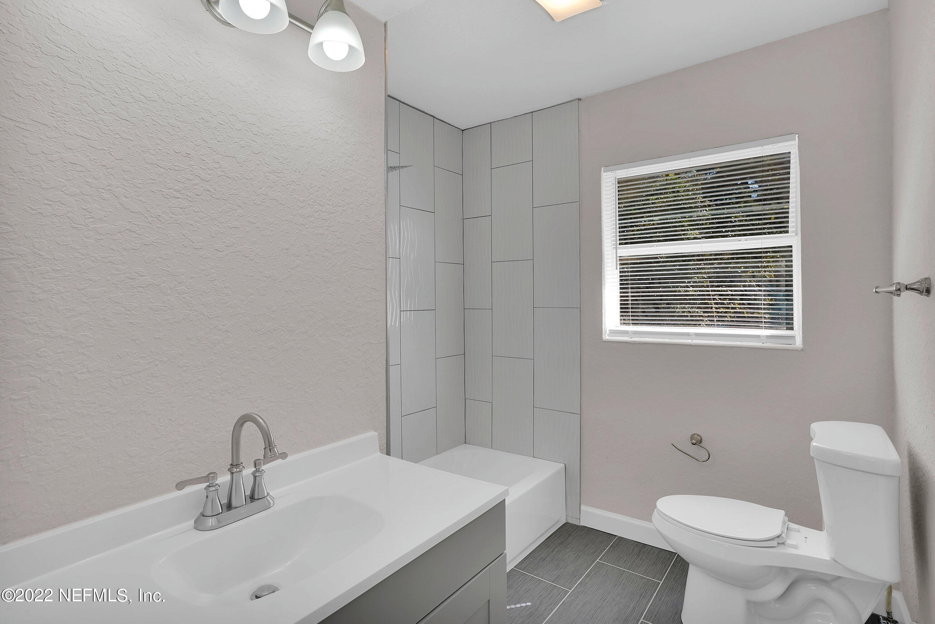6631 Champlain Road Jacksonville, FL 32208 - Photo 15 of 25 a bathroom with a sink a toilet and a mirror