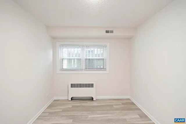 a view of a livingroom with wooden floor and a window