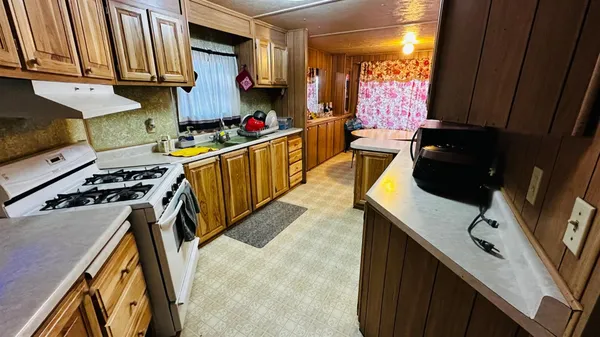 a kitchen with stainless steel appliances granite countertop a sink a stove and a microwave
