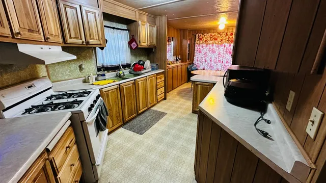 a kitchen with stainless steel appliances granite countertop a sink a stove and a microwave
