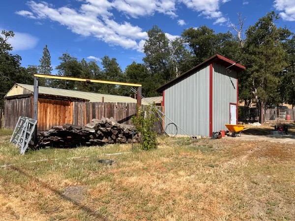 a view of a house with backyard and trees