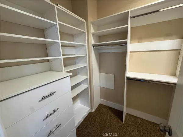a view of walk in closet with empty racks