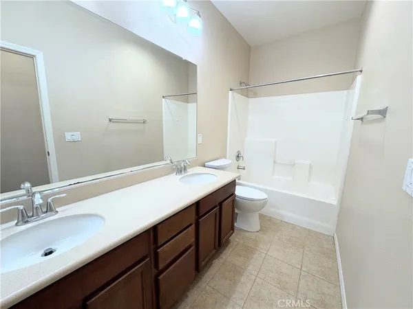 a bathroom with a double vanity sink toilet mirror and shower