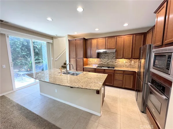 a kitchen with stainless steel appliances granite countertop a stove a sink and a refrigerator
