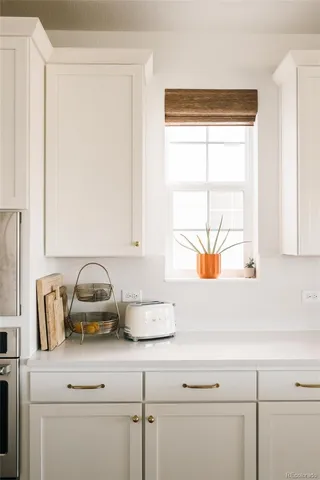 a bathroom with a window sink and cabinets