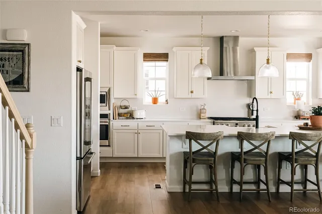 a kitchen with a table chairs refrigerator and cabinets