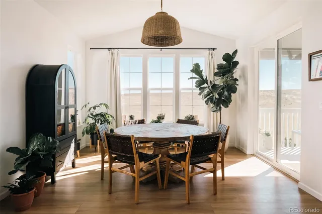 a dining room with furniture potted plants and wooden floor