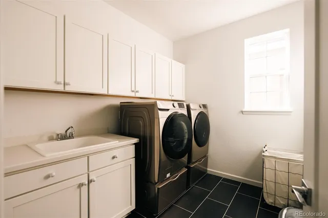 a utility room with sink dryer and washer