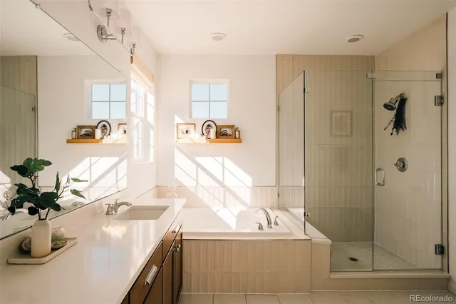 a bathroom with a sink tub shower and a mirror
