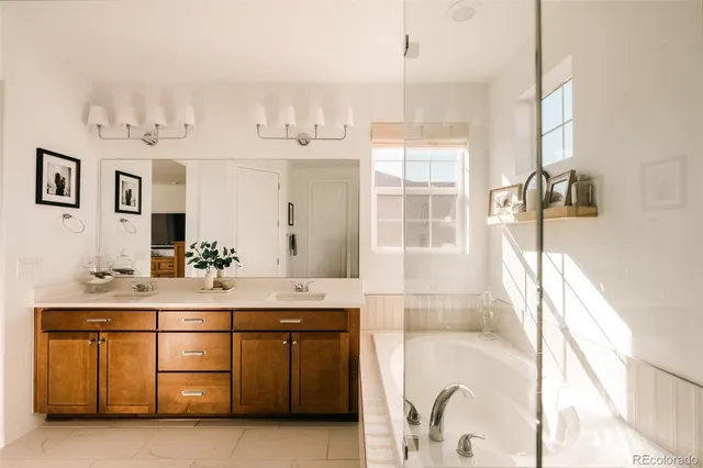 a bathroom with a tub sink and mirror