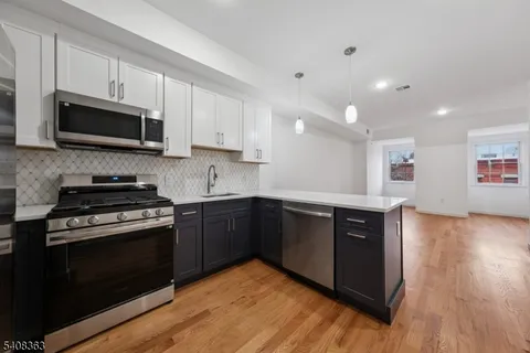 a kitchen with stainless steel appliances granite countertop a stove a sink and a microwave