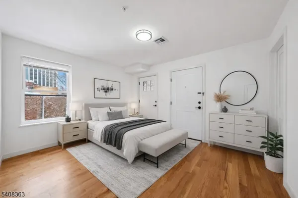 a spacious bedroom with a bed and a dresser