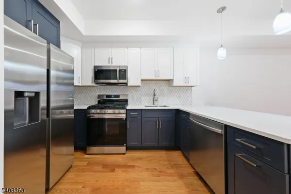 a kitchen with granite countertop a refrigerator and a sink