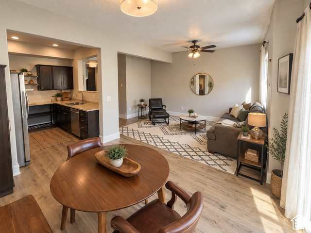 11689 South Shadow View Lane Draper, UT 84020 - Photo 4 of 25 Open-concept living area featuring wood-finish flooring, a kitchen with dark cabinetry and light countertops, and a ceiling fan