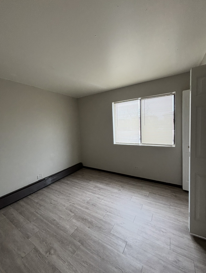 3060 Bernice Avenue, Unit 2N Lansing, IL 60438 - Photo 5 of 6 an empty room with wooden floor and windows
