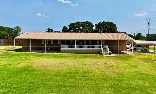 a view of a house with a garden and sitting area