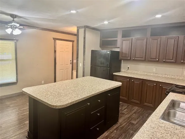 a kitchen with a refrigerator sink and cabinets