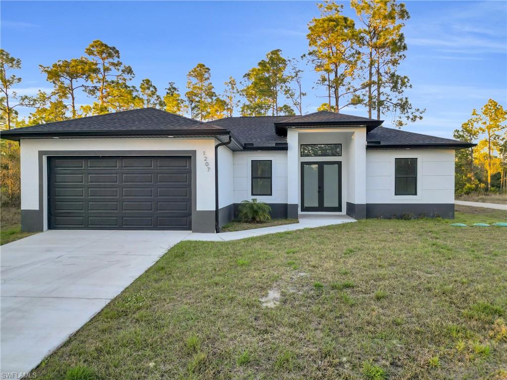 406 West 11th Street Lehigh Acres, FL 33972 - Photo 1 of 24 a front view of a house with a yard and garage