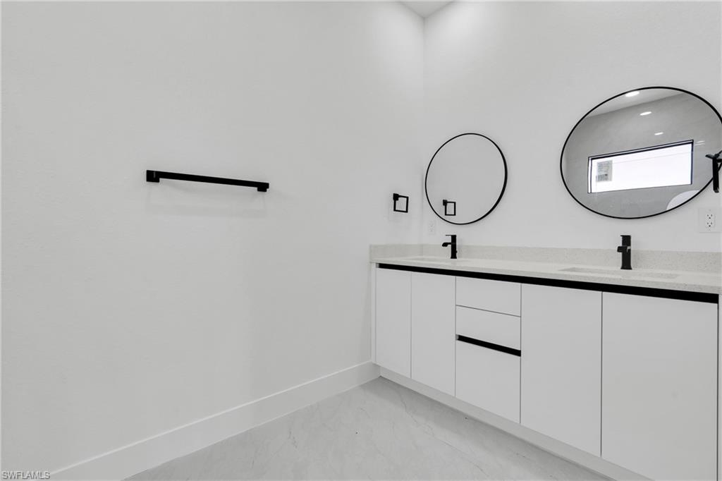 406 West 11th Street Lehigh Acres, FL 33972 - Photo 17 of 24 a bathroom with a sink and mirror