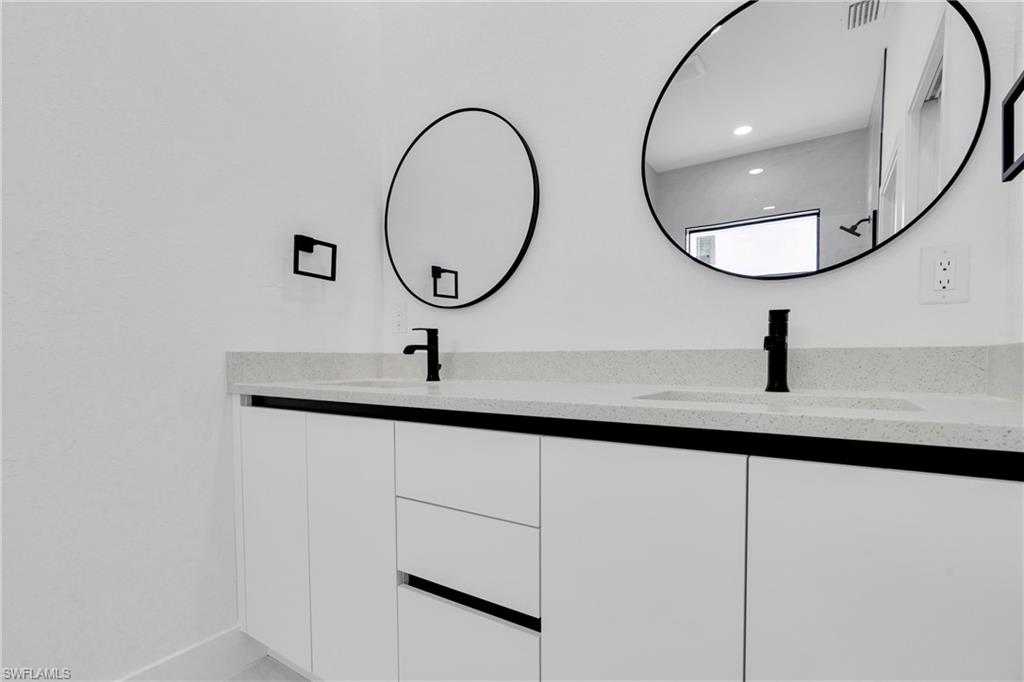 406 West 11th Street Lehigh Acres, FL 33972 - Photo 19 of 24 a bathroom with a sink and a mirror