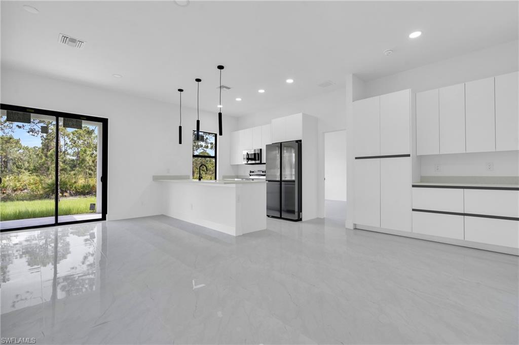 406 West 11th Street Lehigh Acres, FL 33972 - Photo 5 of 24 a view of a kitchen with refrigerator and windows