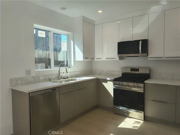 a kitchen with stainless steel appliances a stove sink and microwave
