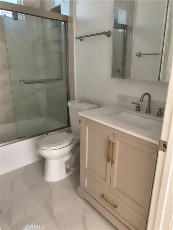 a white toilet sitting next to a bathroom sink