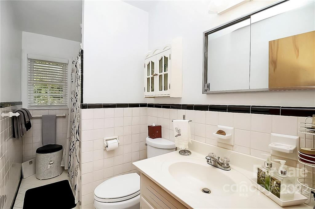 4114 Murrayhill Road Charlotte, NC 28209 - Photo 16 of 28 a bathroom with a sink vanity mirror and toilet