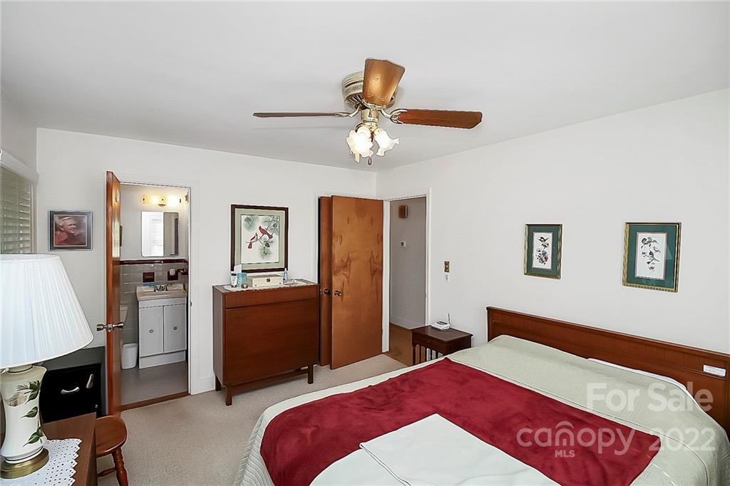 4114 Murrayhill Road Charlotte, NC 28209 - Photo 18 of 28 a bedroom with a bed and a chandelier