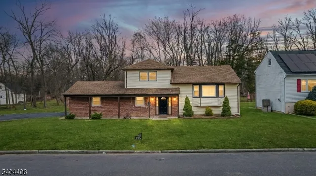 a front view of a house with a yard and trees