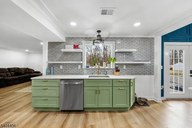 a kitchen with a sink cabinets and wooden floor