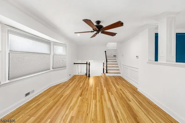 a view of a room with wooden floor and ceiling fan
