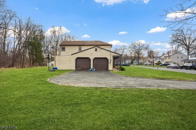 a view of a white house with a big yard and large trees