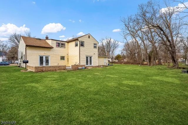 a view of a house with a big yard and large trees