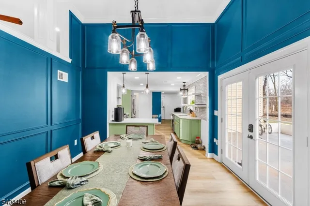 a view of a dining room with furniture a kitchen and chandelier