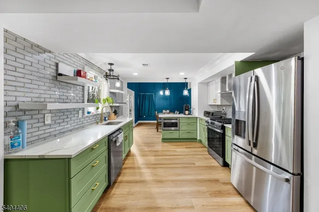 a large kitchen with a large counter top stainless steel appliances and cabinets